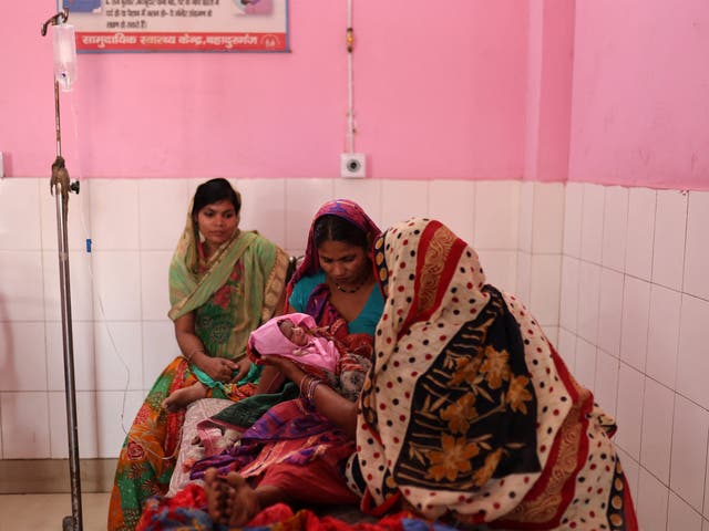 <p>Zamerun Nisha, 33, holds her newborn baby on the maternity ward of a community health centre in the state of Bihar, India</p>
