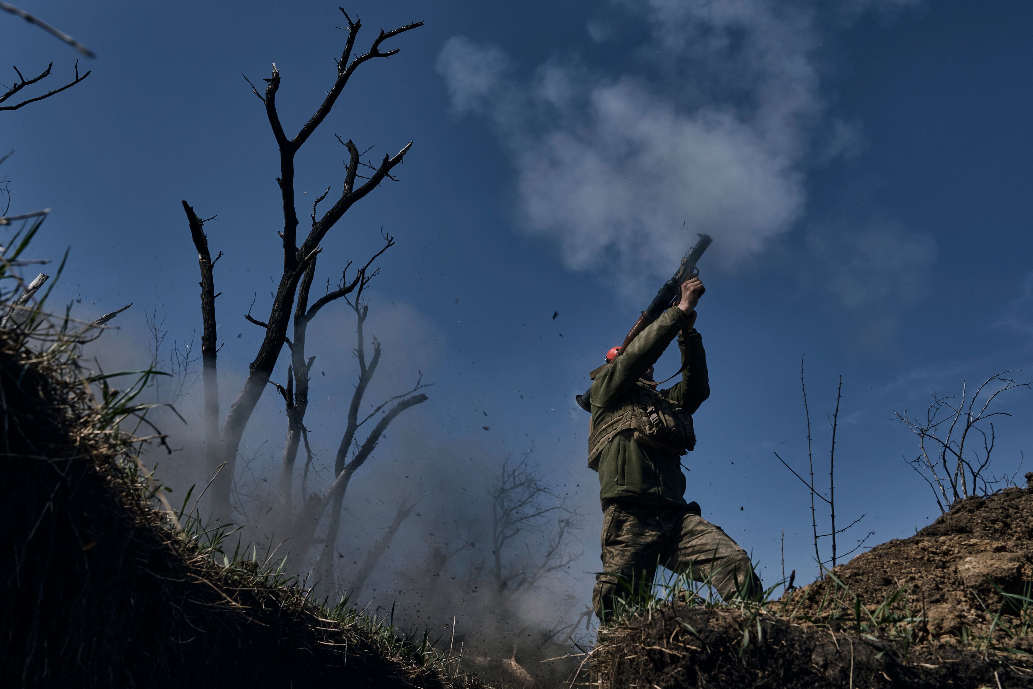 A Ukrainian soldier fires a grenade launcher on the frontline in Bakhmut (LIBKOS/AP)