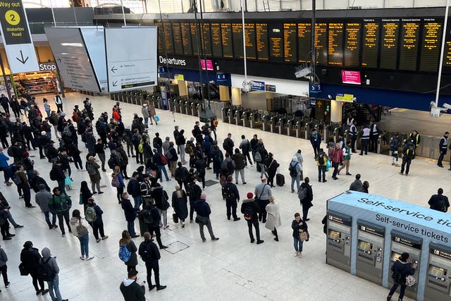 <p>Waiting game: Commuters at London Waterloo, the busiest rail station in the UK, which is mostly closed</p>