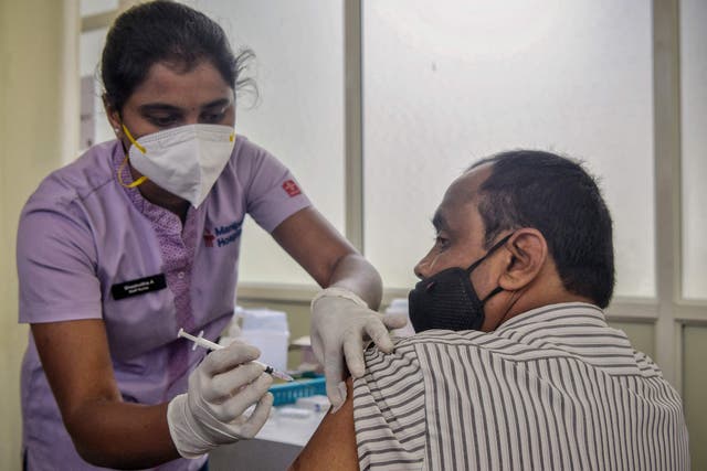 <p>A health worker inoculates a man with the Covid-19 vaccine in India</p>