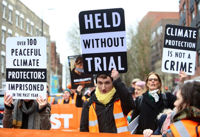 <p>Activists from the Just Stop Oil climate change campaign group hold up placards as they march from Pentonville Prison in protest at the holding of political prisoners</p>