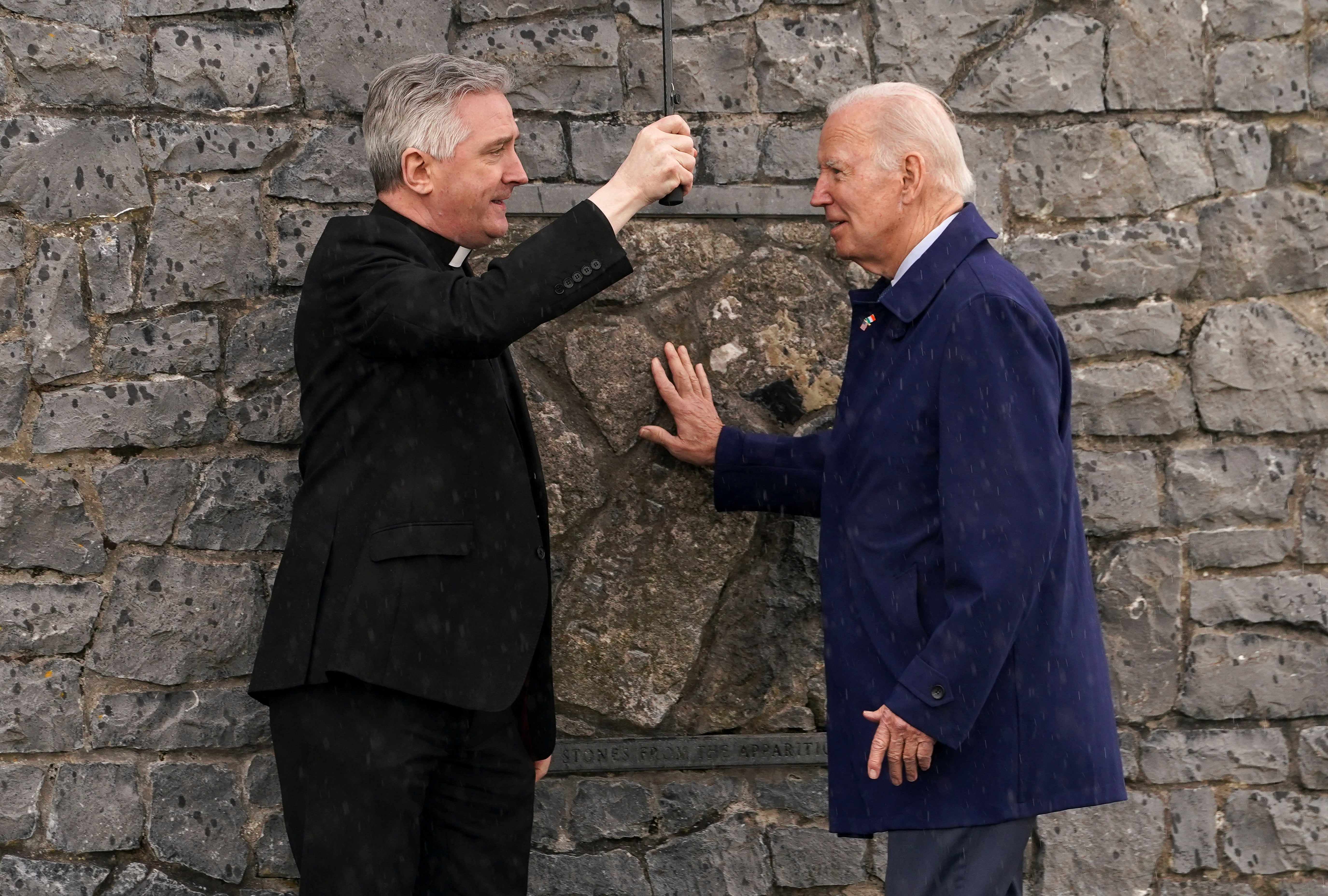 Joe Biden touches the original gable wall of the church at the Knock Shrine