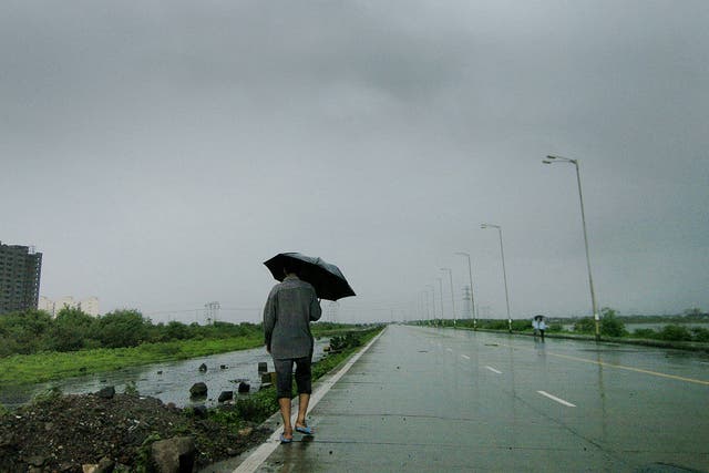 <p>A Mumbai resident makes his way home along the deserted Wadala highway</p>