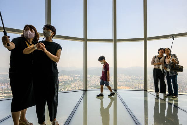 <p>File. People pose for selfies at the Lotte World Tower Seoul Sky on 12 August 2022. - South Korean government has decided to pay an allowance to reclusive youths to help them get out of their homes</p>