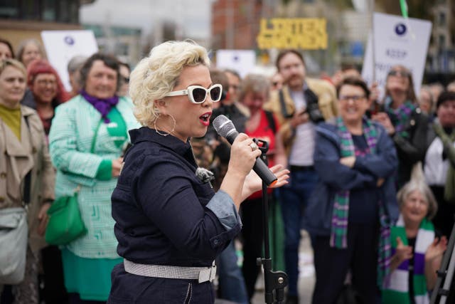 <p>Women’s rights activist ‘Posie Parker’ (real name Kellie-Jay Keen) addresses the crowd during a Let Women Speak rally in Belfast (Niall Carson/PA)</p>