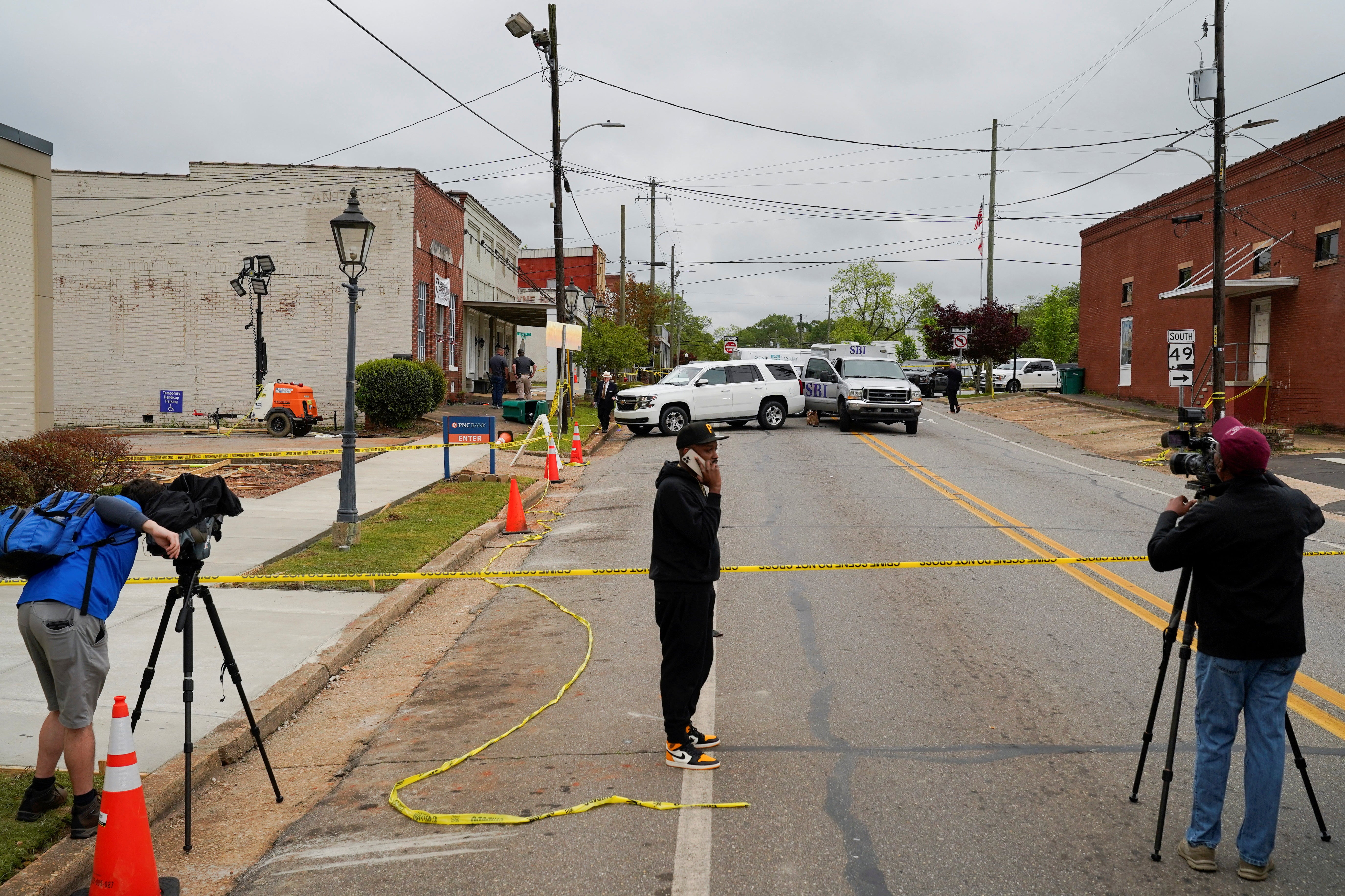 <p>Community members and media stand near the crime scene (16 April 2023)  </p>