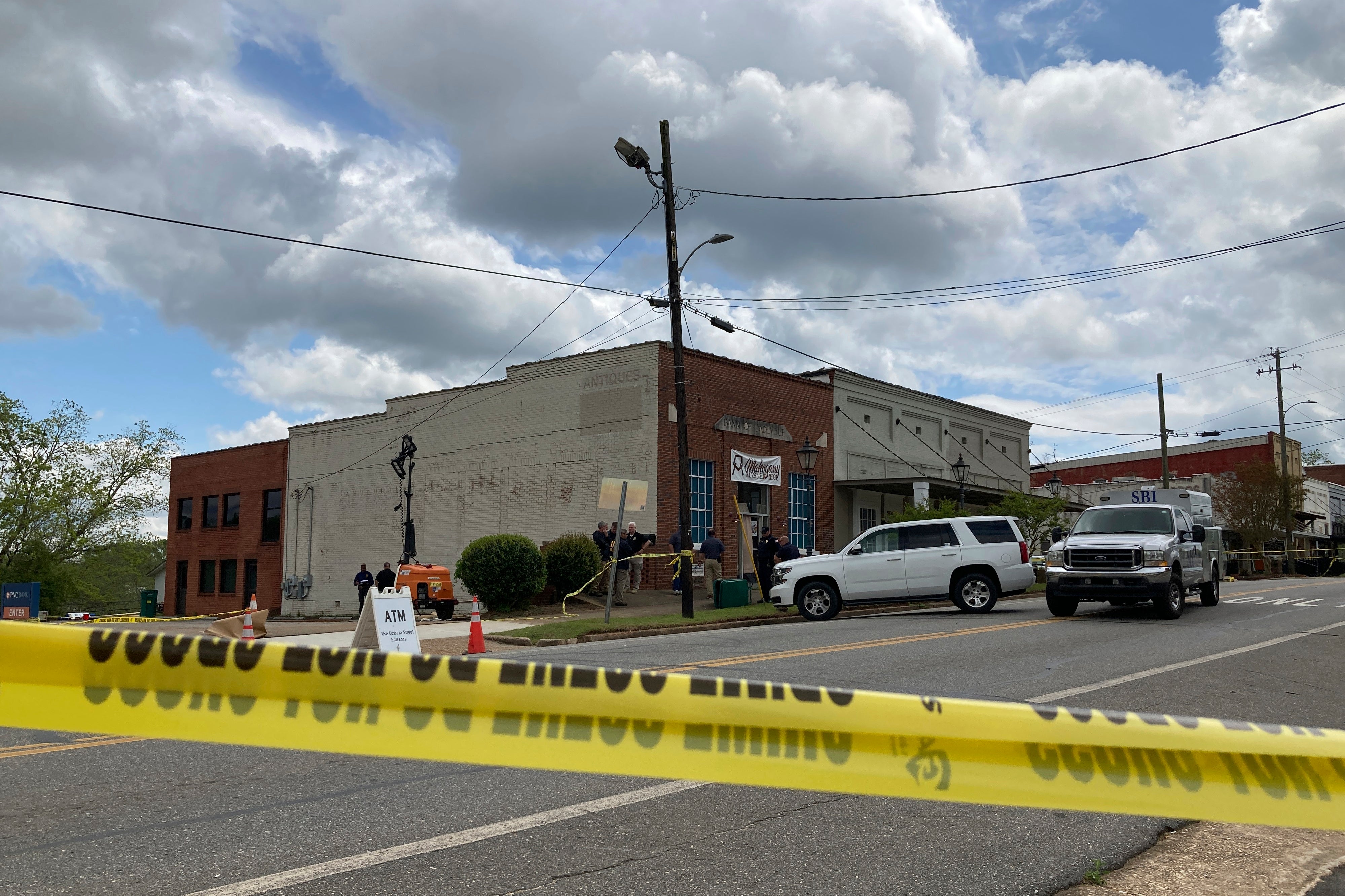 <p>Investigators work at the site of a fatal shooting in downtown Dadeville, Alabama on Sunday, 16 April </p>