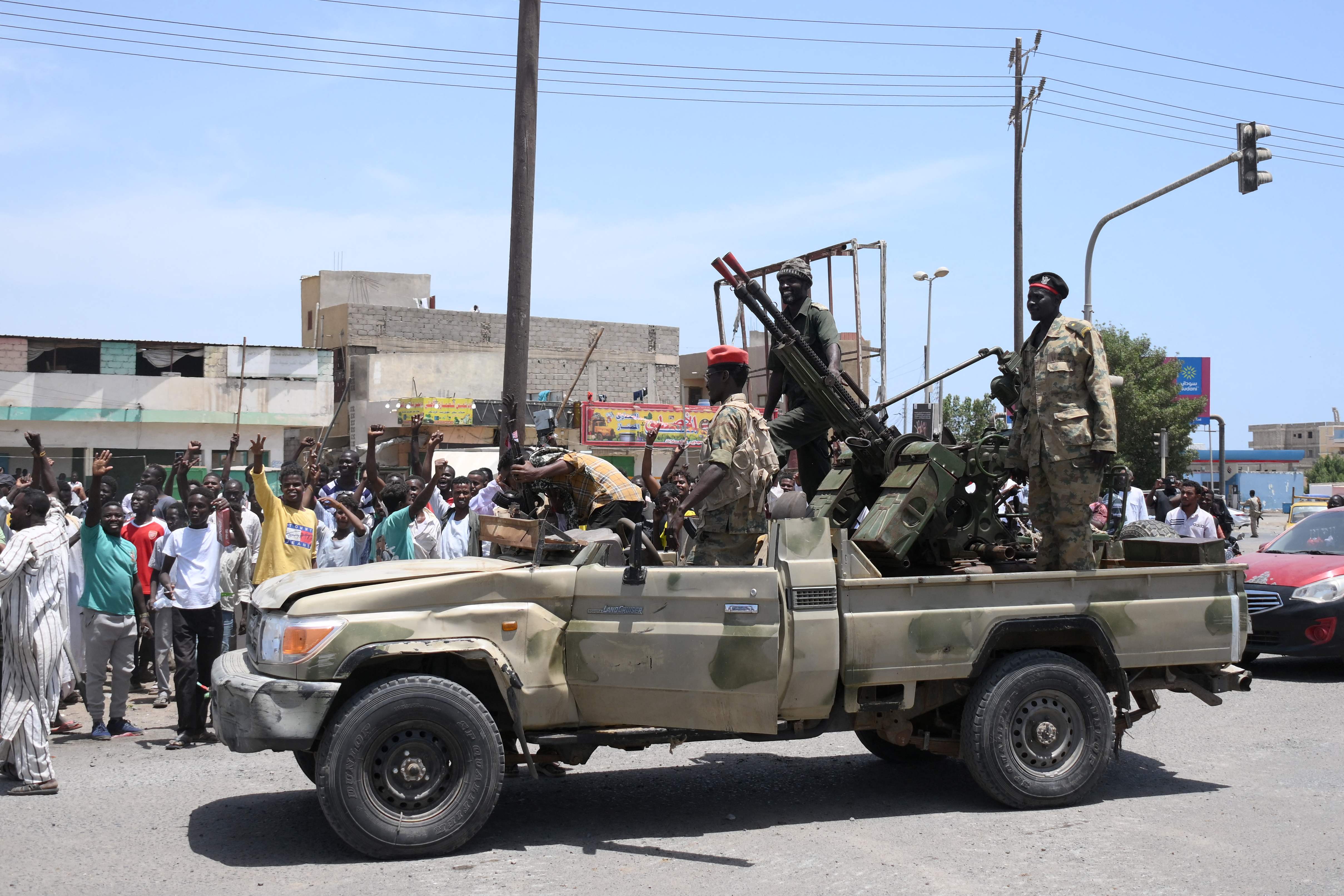 Sudanese people greet army soldiers, loyal to army chief Abdel Fattah al-Burhan, in the Red Sea city of Port Sudan