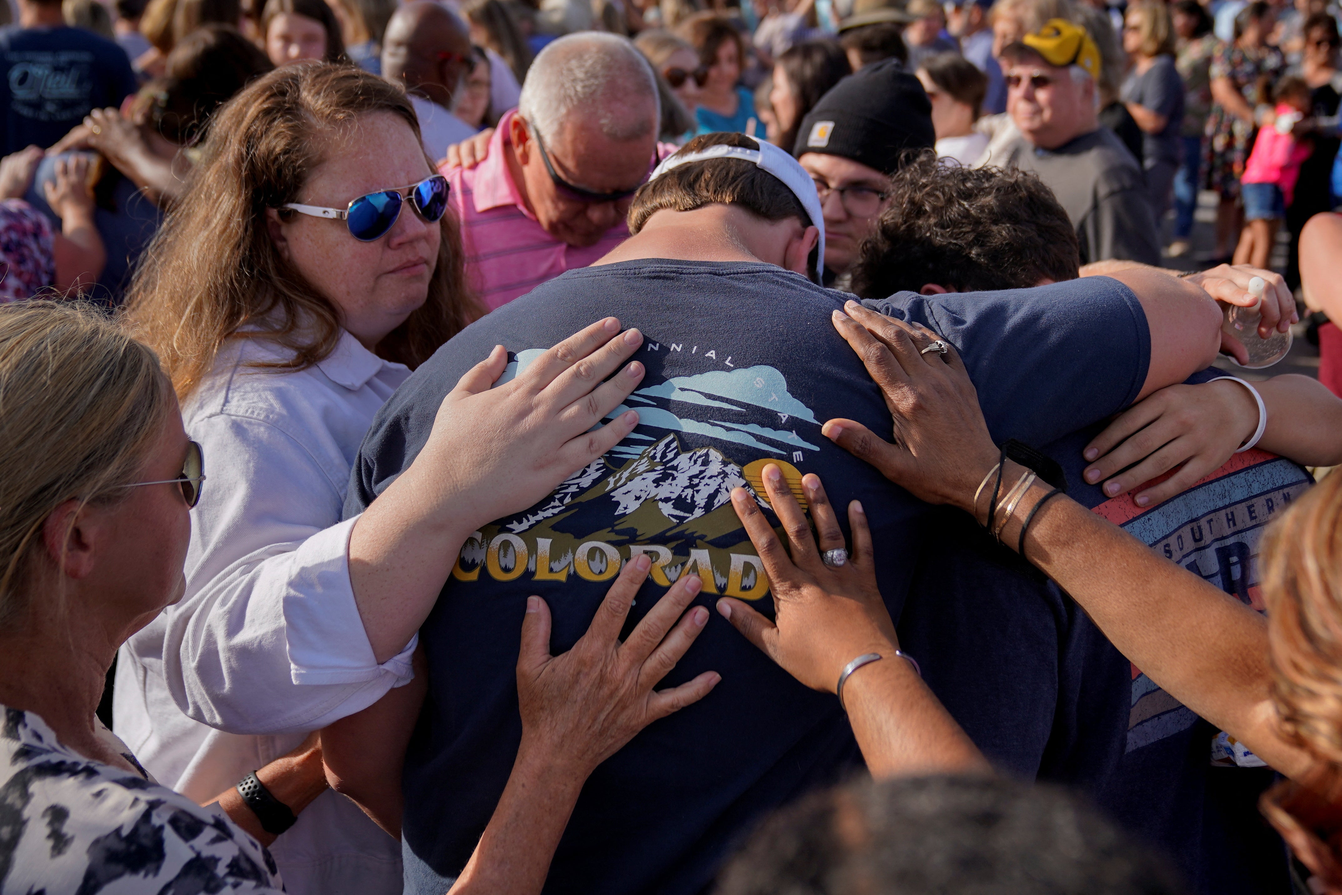 Community members embrace each other during the vigil on Sunday evening