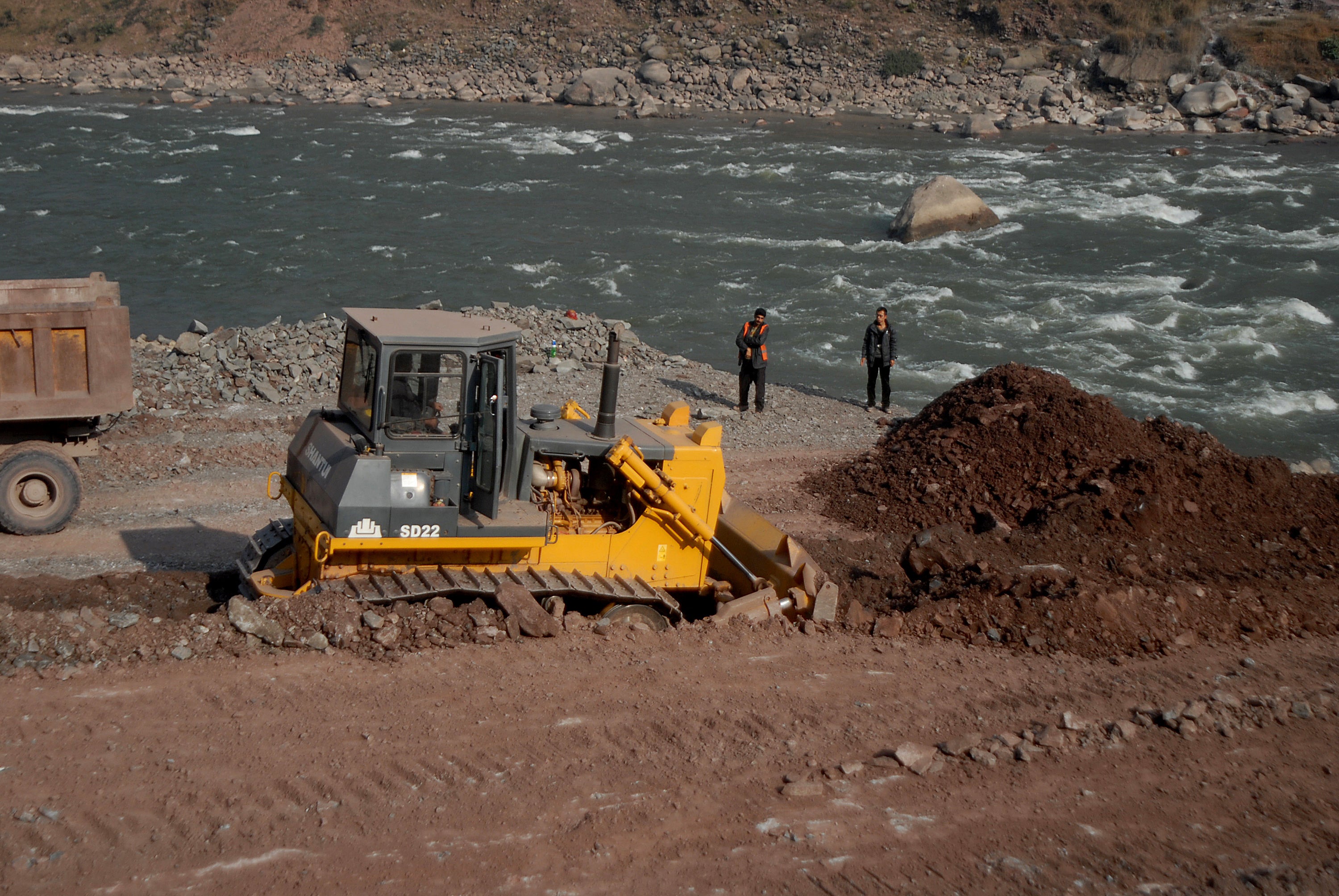 File A Chinese engineer (R) supervise workers preparing a road along a river in Ghari Dopatta, some 22 kms from Muzaffarabad, the capital of Pakistani-administered Kashmir in 2013