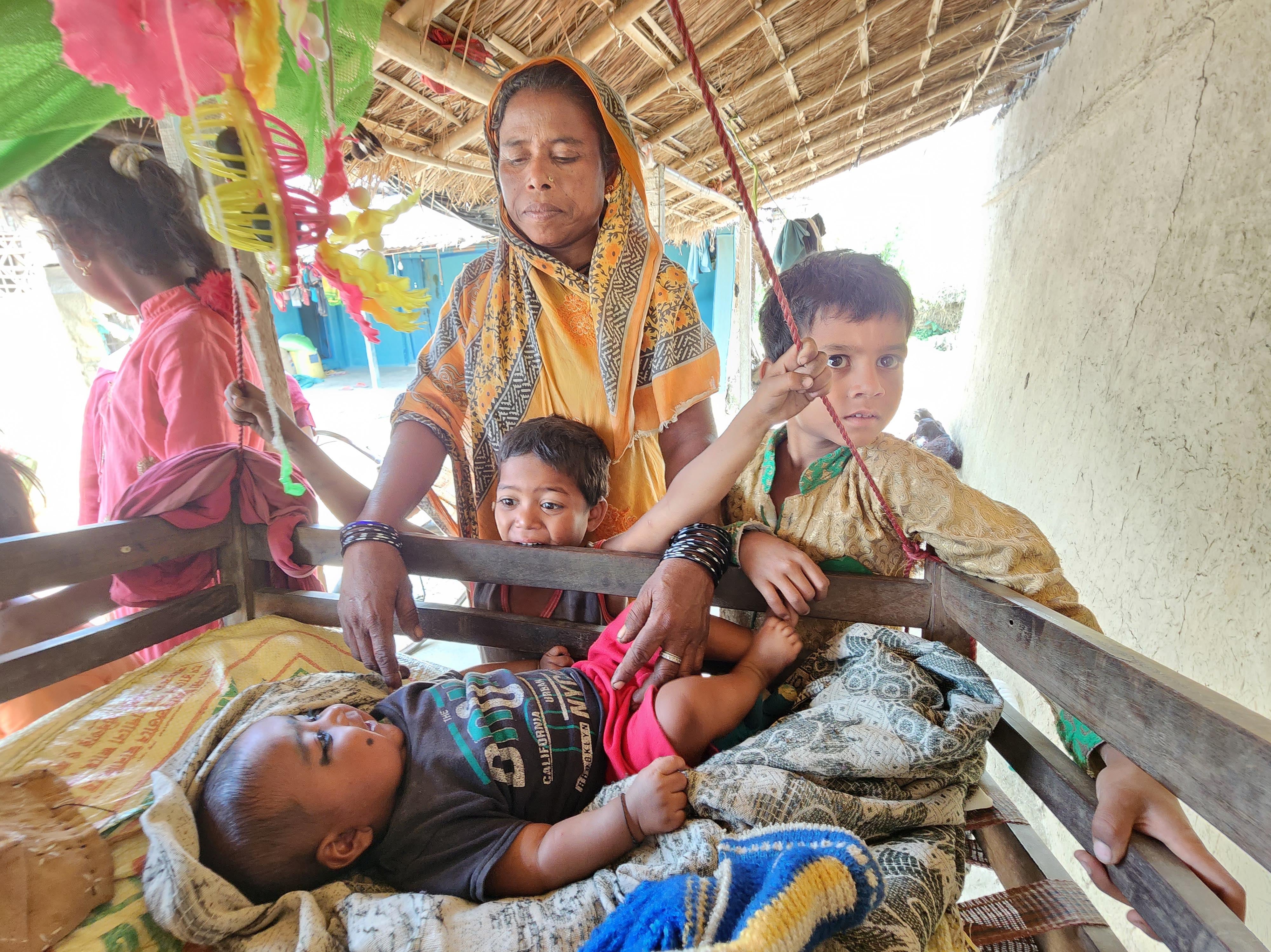Parveen Begum, who has had 11 children, tends to her latest child as her extended family huddles around her