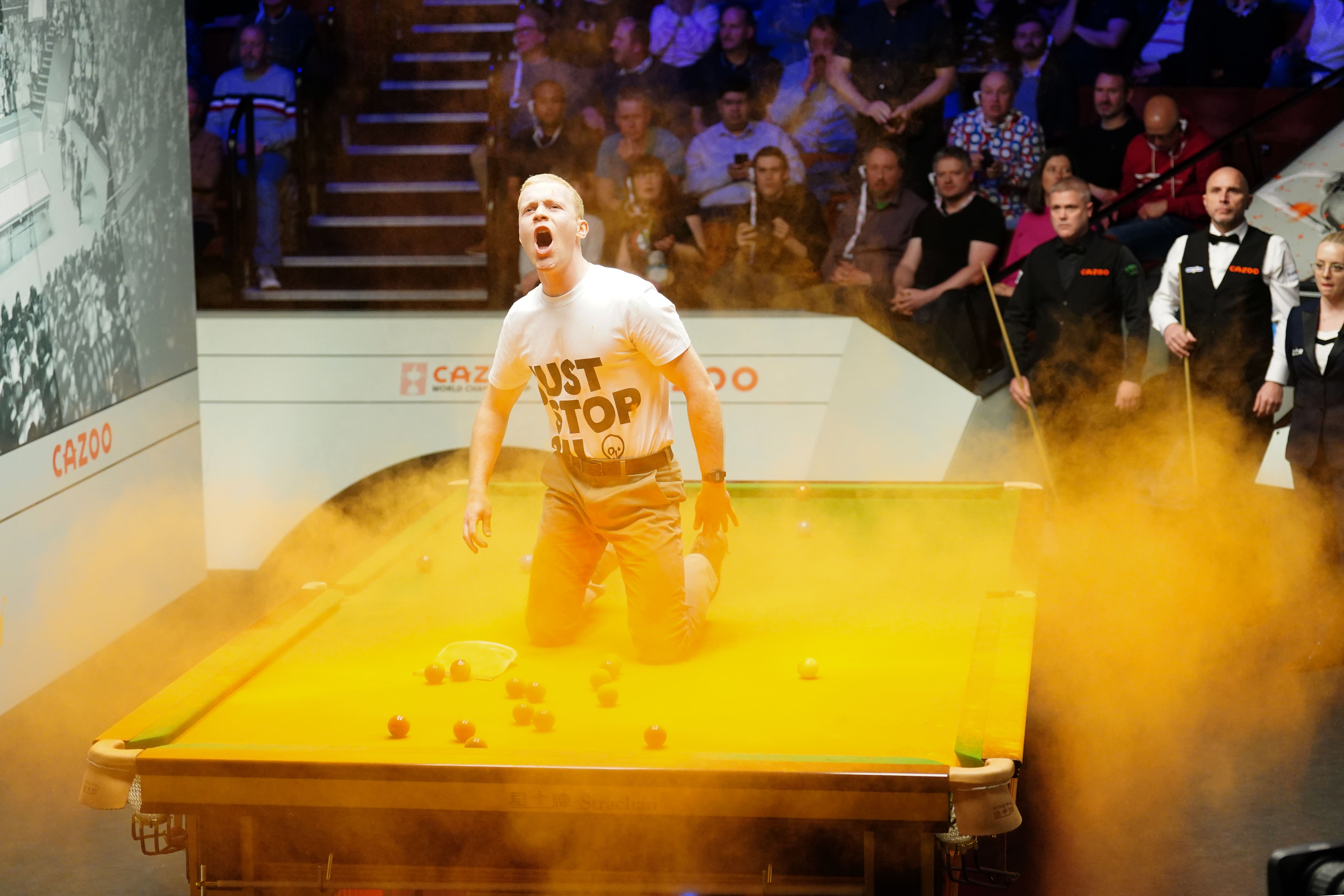 <p>A ‘Just Stop Oil’ protester interrupts the World Snooker Championship in Sheffield in April </p>