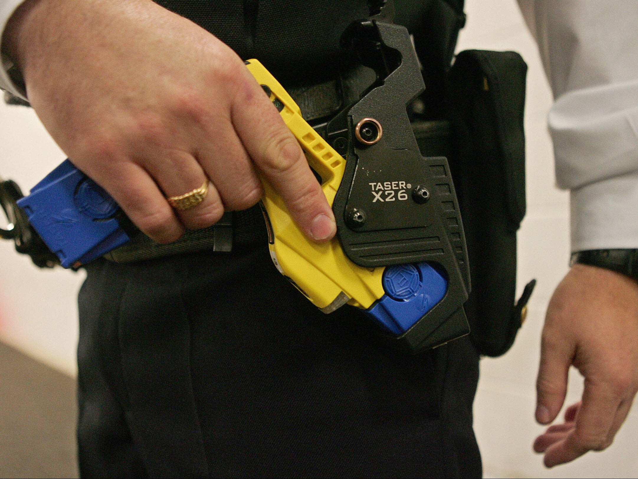 A British police officer holsters a taser gun at the Metropolitan Police Specialist Training Centre in Kent