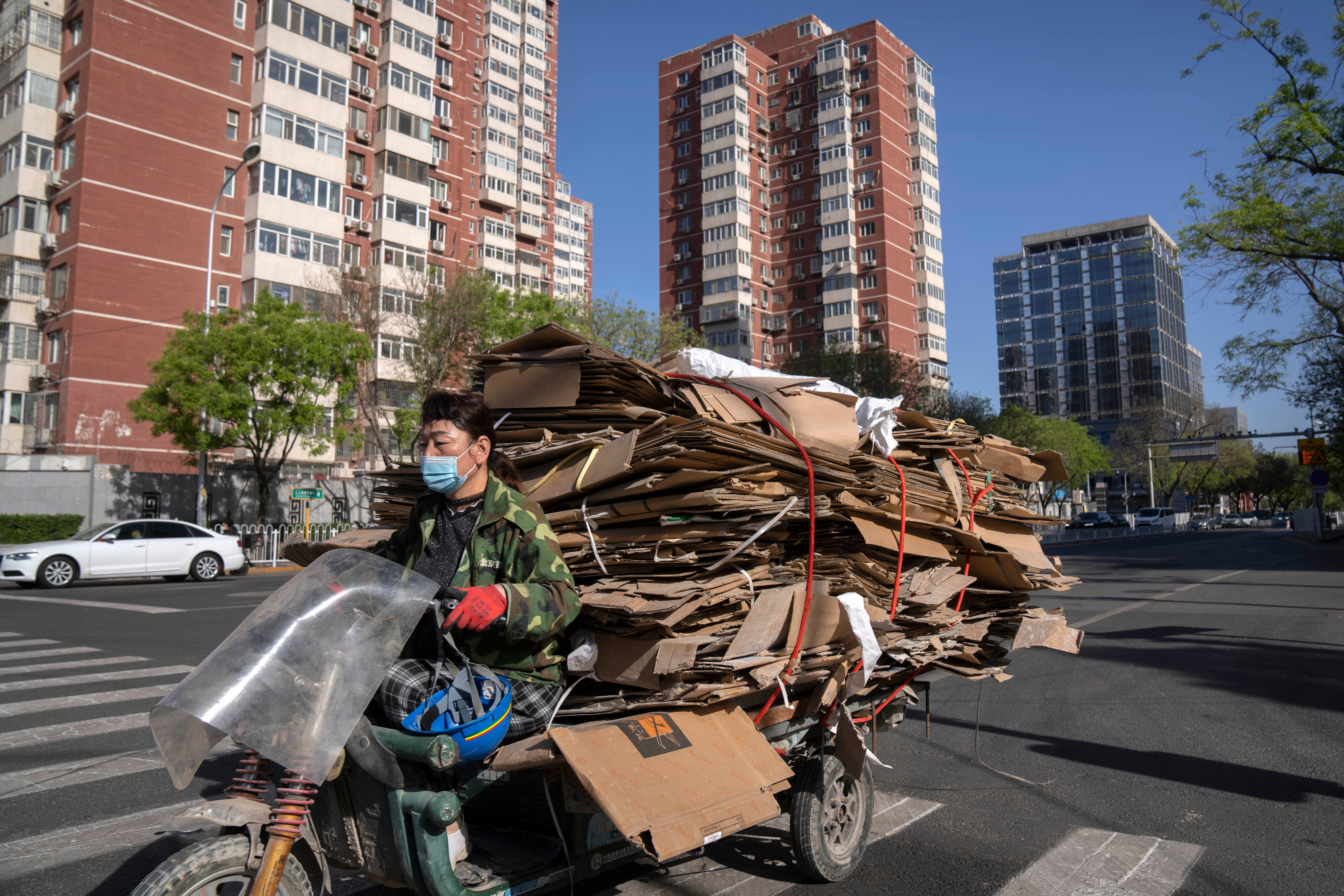 Heading for the scrapheap? A recycler drives a cart loaded with cardboard along a street in Beijing