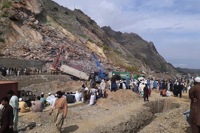 <p>Local residents gather as authorities use heavy machines to search survivors and clear the rubble following a landslide in northwestern Pakistan </p>