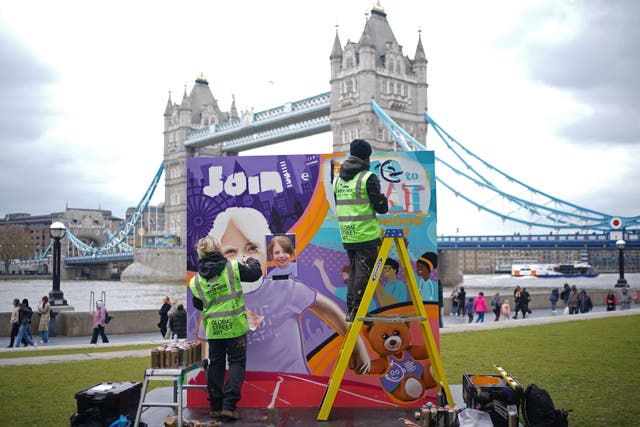 Artists Nacho, right, and Elle, from Global Street Art, put the finishing touches to an 8ft mural of ‘leading the race’ against childhood cancer, at Potters Fields Park in London, to raise awareness of the race to build a new Children’s Cancer Centre at Great Ormond Street Hospital (Yui Mok/PA)