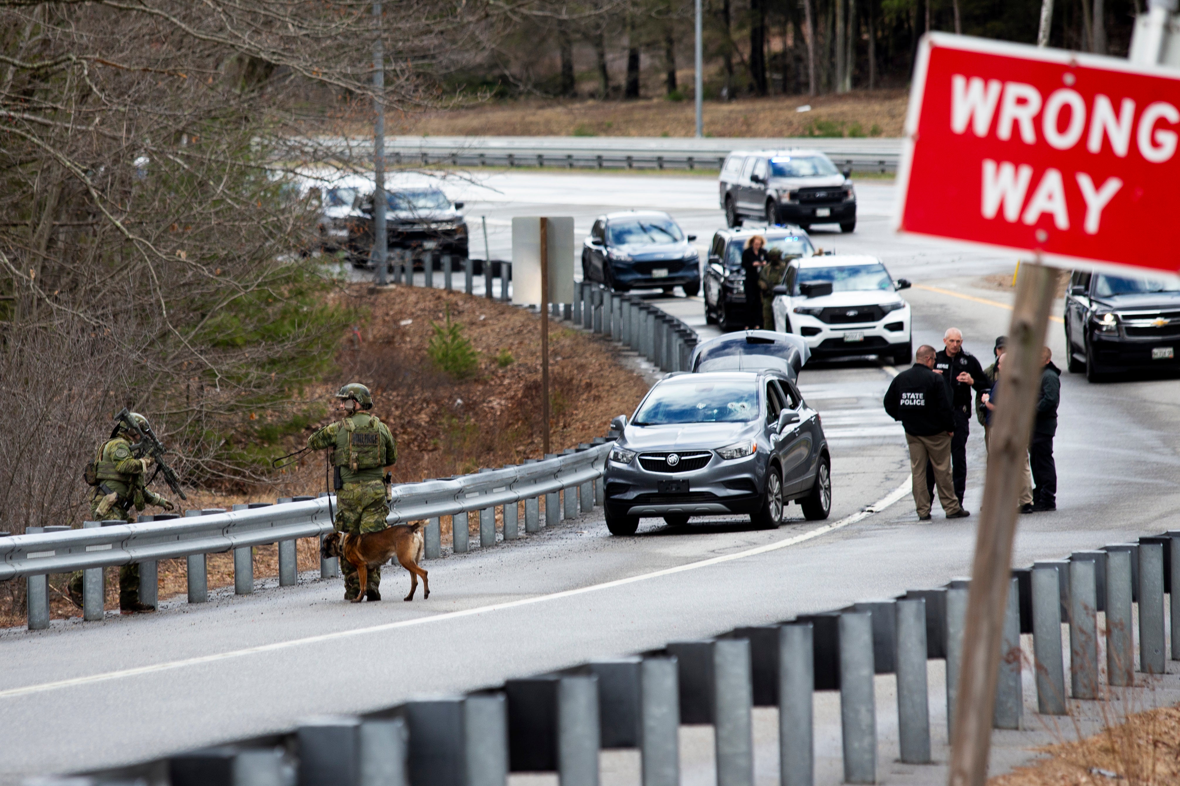 Members of law enforcement investigate a scene where people were injured in a shooting on Interstate 295, in Yarmouth, Maine