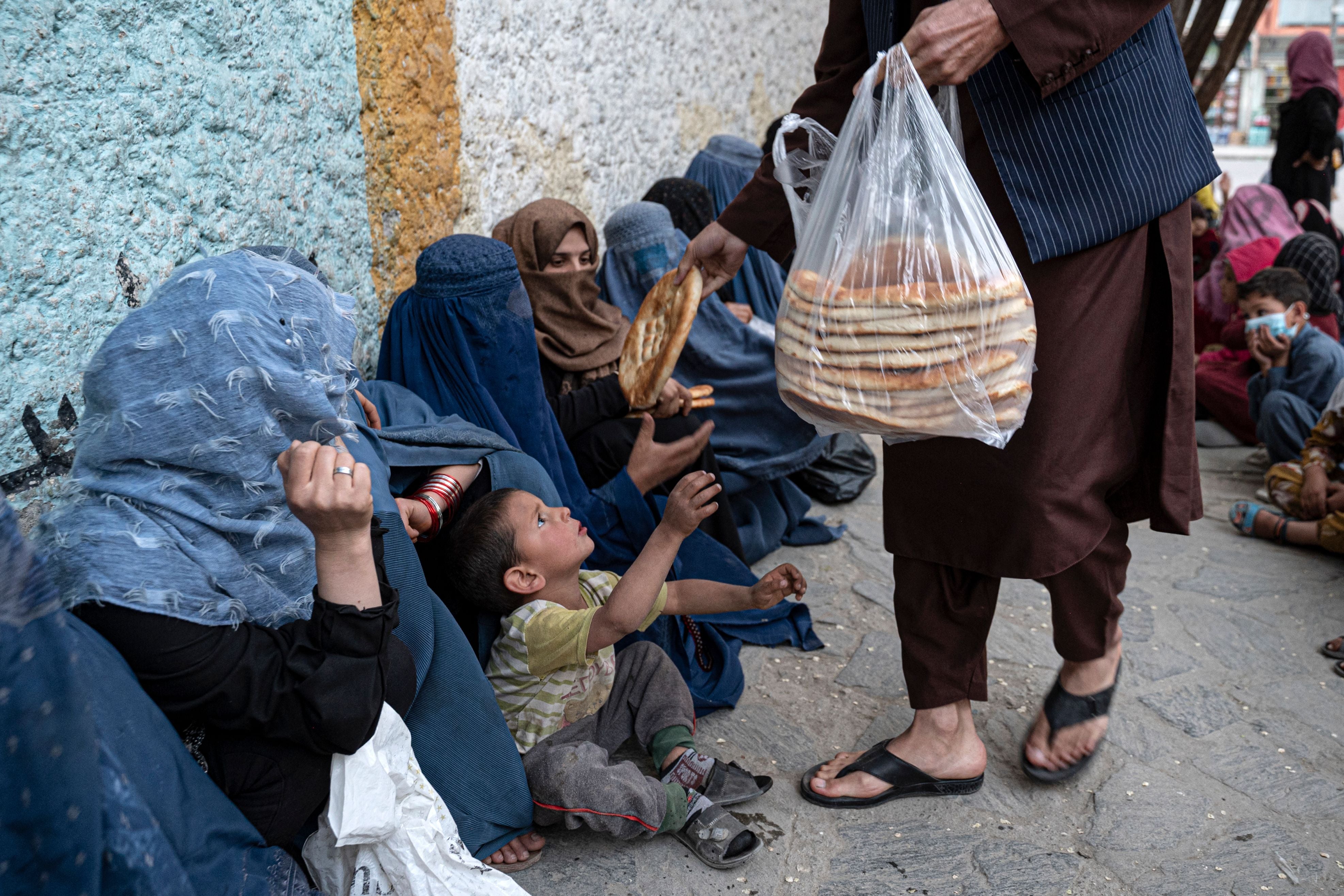 Afghan women collect free bread from a charity during the holy fasting month of Ramadan in Kabul