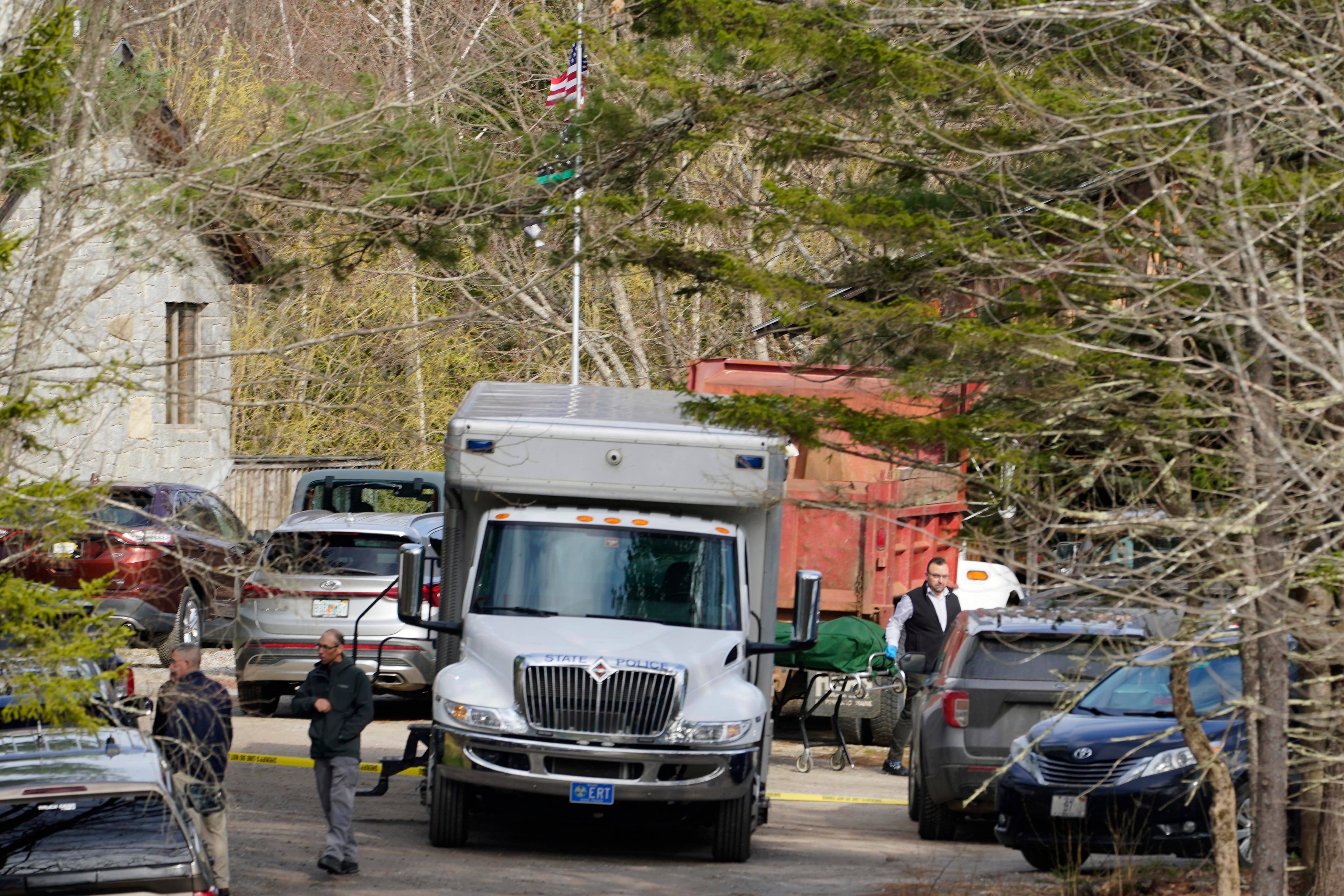 A body is wheeled to a hearse at the scene of a shooting in Bowdoin, Maine