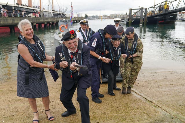 D-Day veteran Joe Cattini raises his walking stick like a machine gun as he and other veterans are welcomed to the Portsmouth Historic Dockyard to commemorate the 77th anniversary of the Normandy Landings. Picture date: Sunday June 6, 2021.