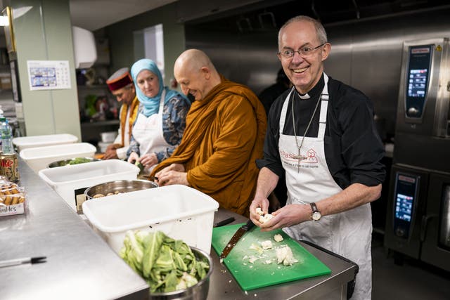 The Archbishop of Canterbury prepares food at the Passage in London (Aaron Chown/PA)