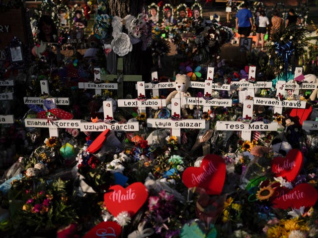 <p>Flowers are piled around crosses with the names of the victims killed in a school shooting as people visit a memorial at Robb Elementary School to pay their respects May 31, 2022, in Uvalde, Texas</p>