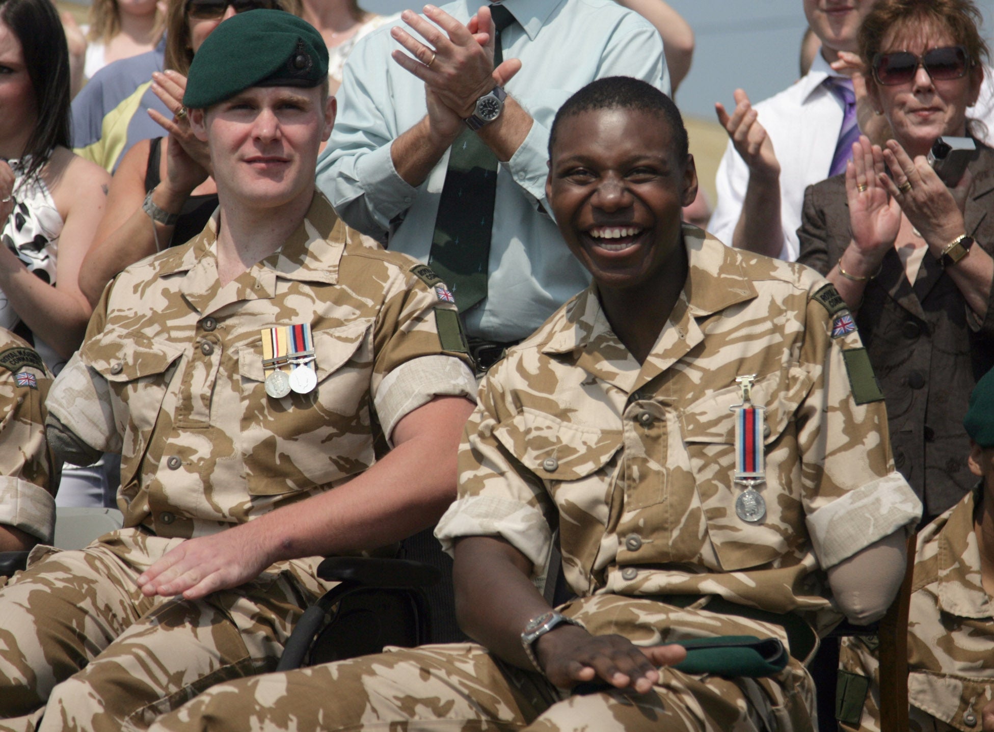 Mark Ormrod, 24 and Ben McBean, 21, smile as their comrades march past during a parade at the 40 Commando Royal Marines Operation Herrick 7 Medal Parade