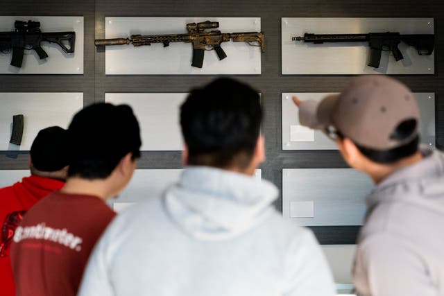 <p>Customers look at AR-15-style rifles on a mostly empty display wall at Rainier Arms Friday, April 14, 2023, in Auburn, Wash</p>