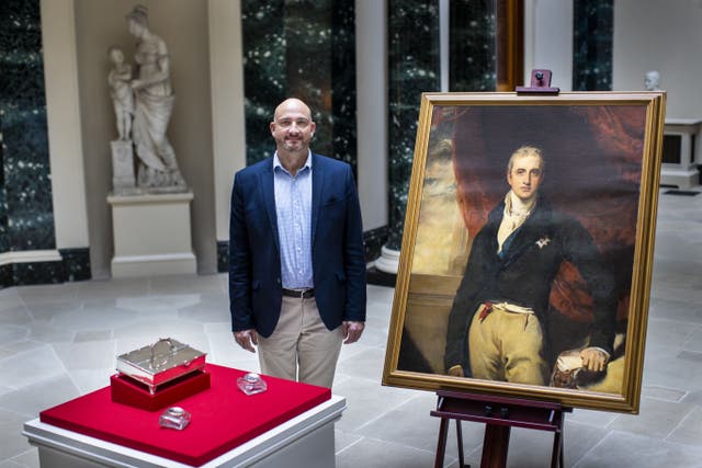 Dr Christopher Warleigh-Lack, National Trust property curator looks at an inkstand and inkwells belonging to Viscount Castlereagh (Liam McBurney/PA)