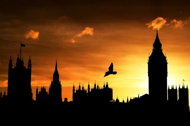 The sun sets behind the Houses of Parliament in London (PA)