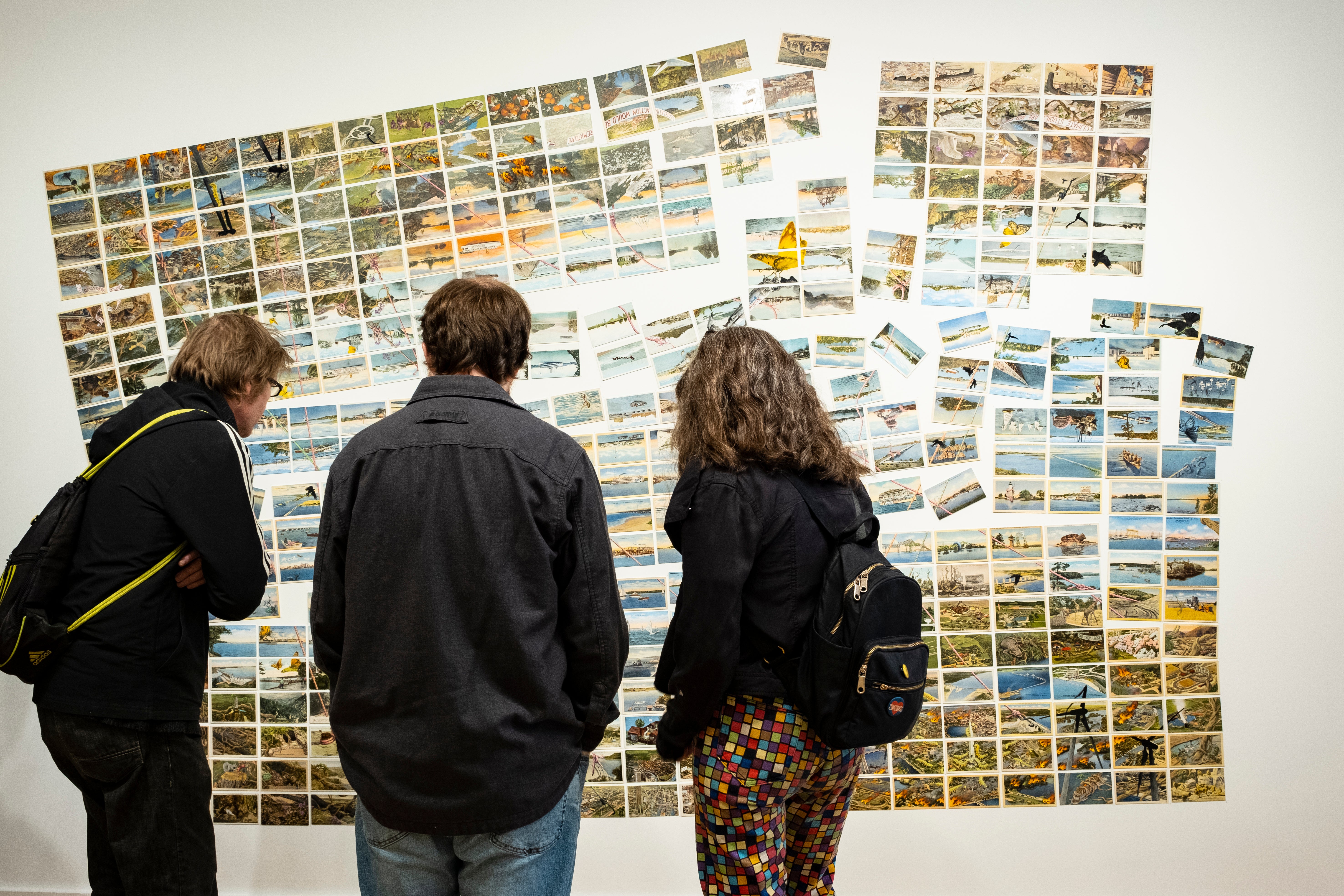Visitors to The Climate Museum view the postcard mural, Someday, all this, by the artist David Opdyke
