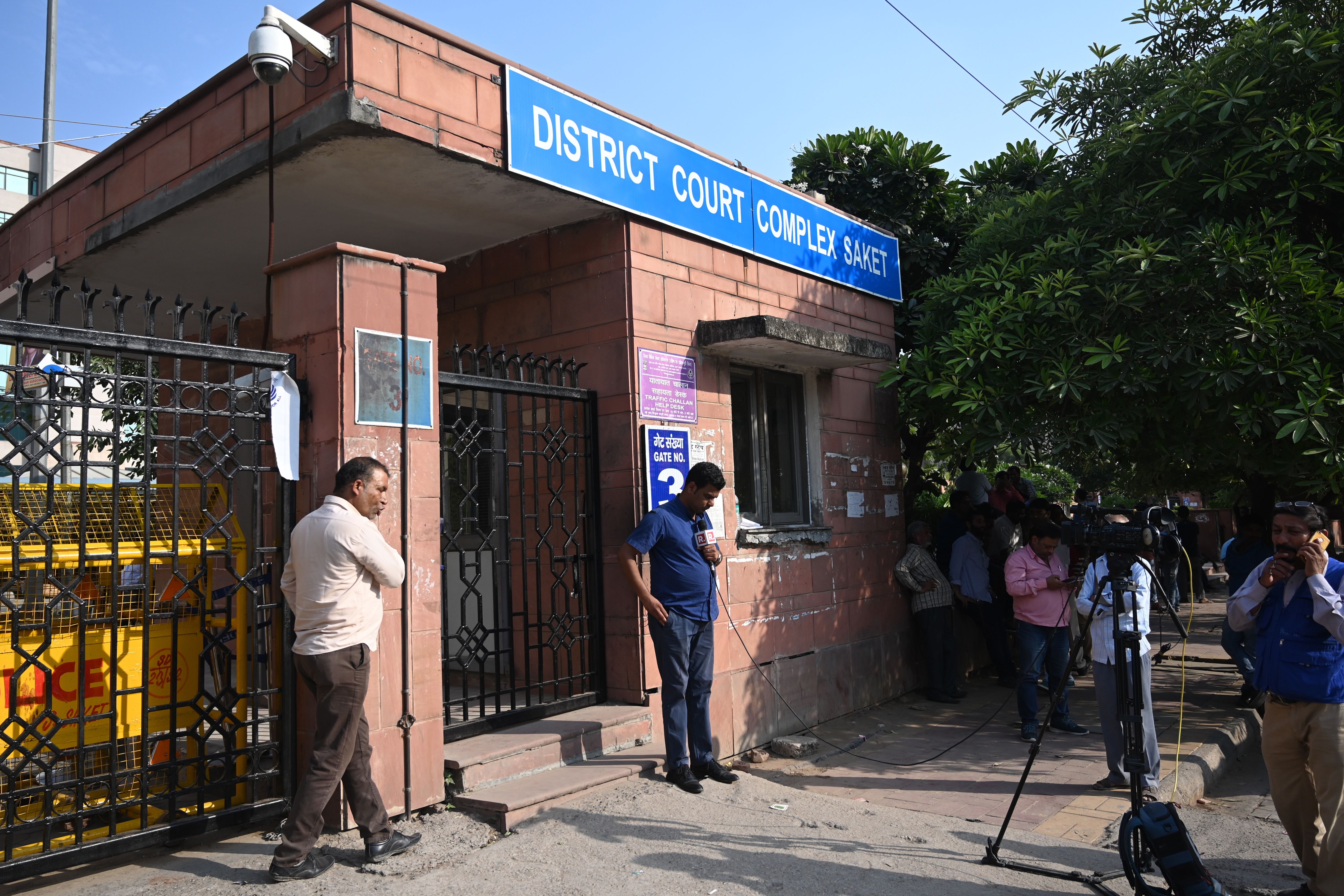 Media representatives stand outside the Saket court complex in New Delhi on 6 November 2019