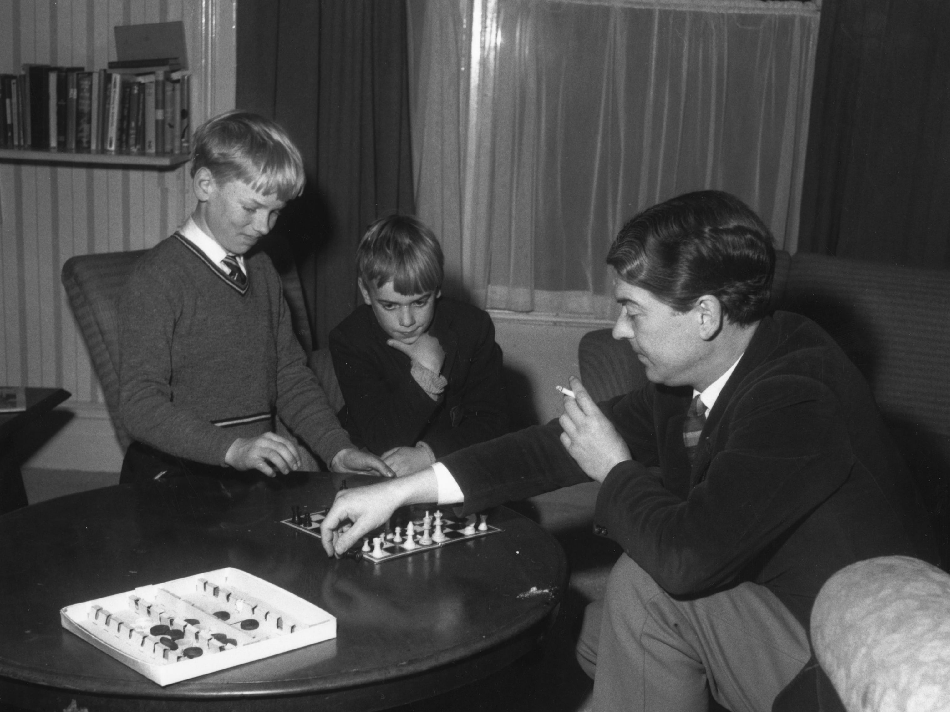 English poet and novelist Kingsley Amis with his sons Martin (left) and Philip playing chess, 1961