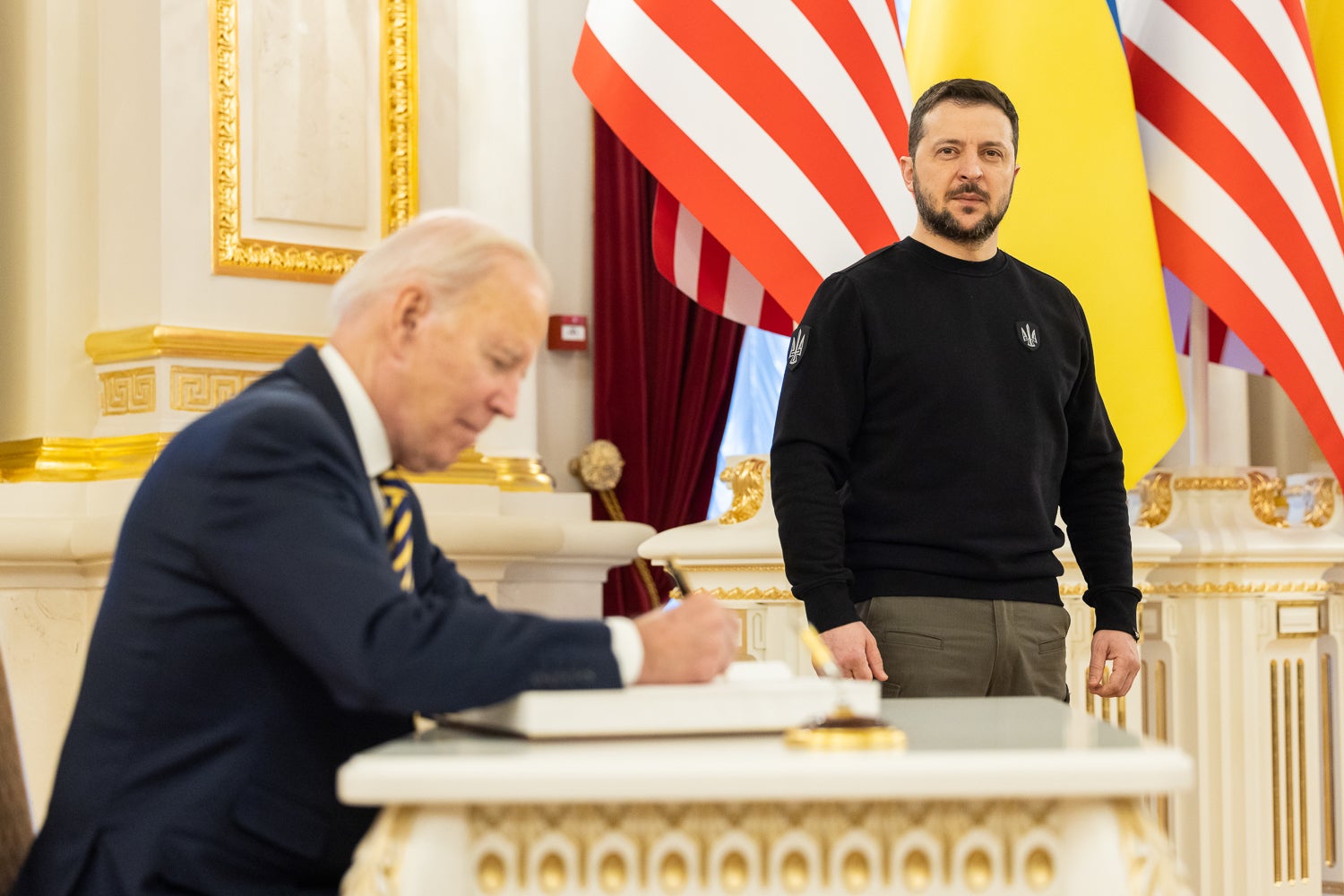 Biden signs the guest book during a meeting with Zelensky at the Ukrainian presidential palace