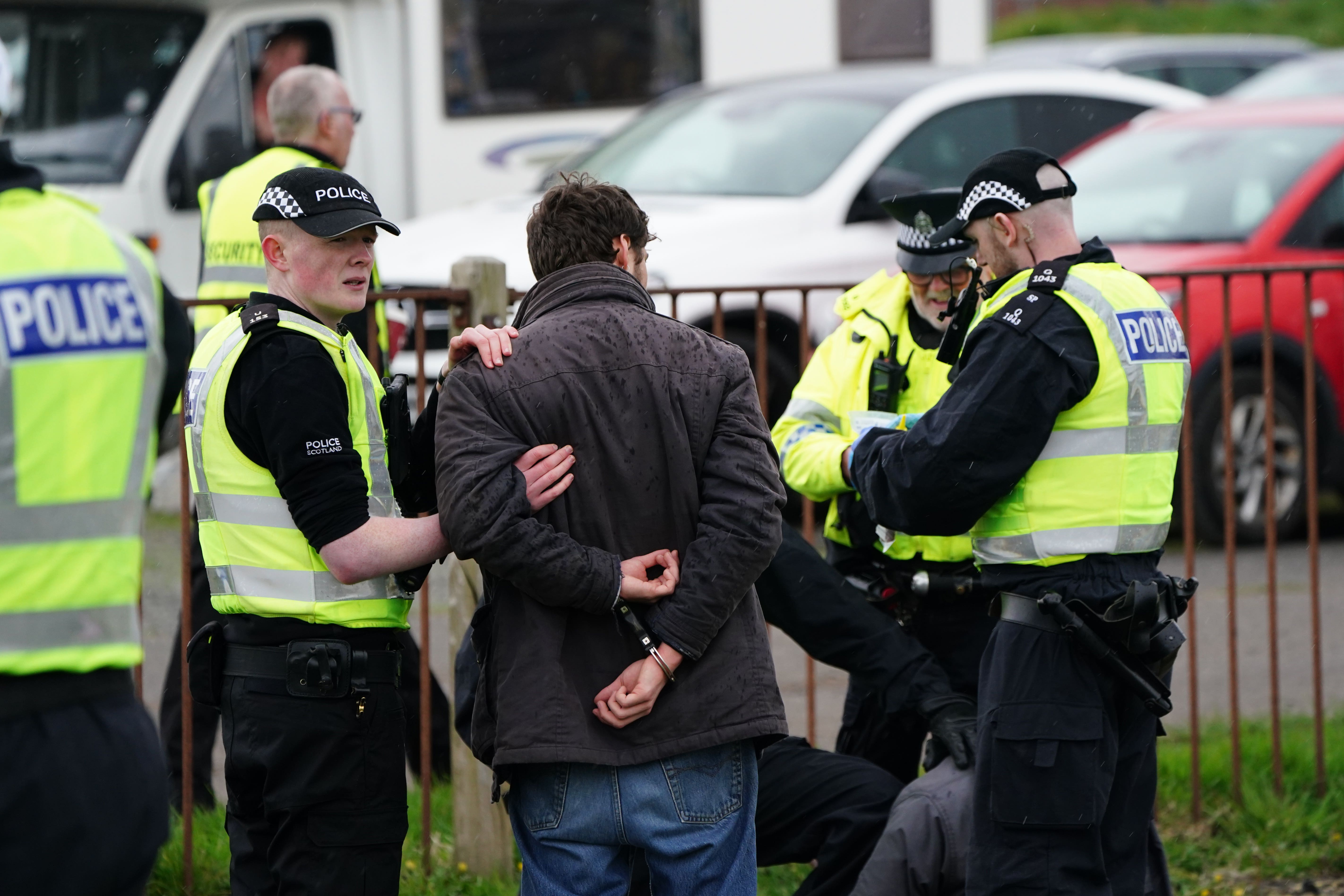 Animal Rising activists are apprehended by police officers as they attempted to invade the race course during the Coral Scottish Grand National festival at Ayr Racecourse. Picture date: Saturday April 22, 2023.