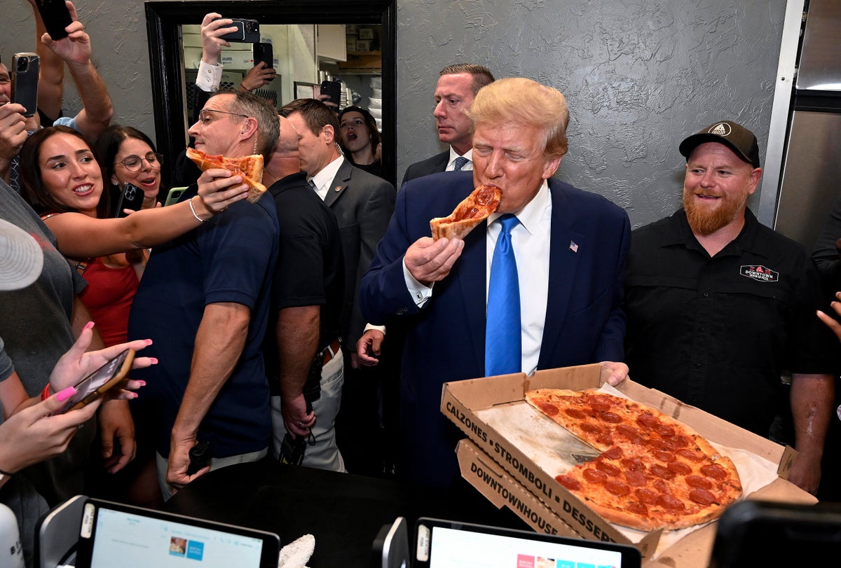 Trump offers fans a slice of pizza – after taking a massive bite out of it