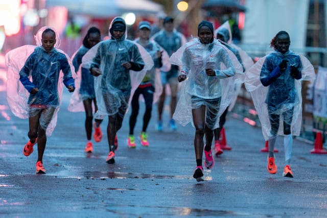 Athletes in the Elite Women’s Race competitors warm up wearing rain covers during the Virgin Money London Marathon around St James’ Park (Bob Martin for London Marathon Events/PA)