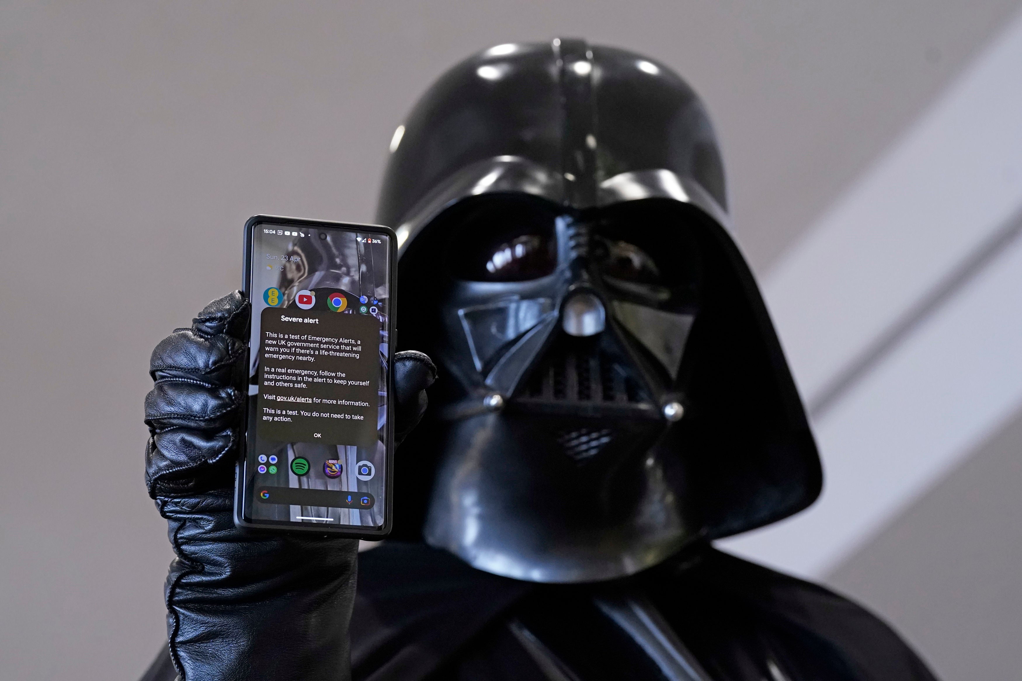 A cosplayer holds up his mobile phone as the test message is displayed during a sci-fi event in Scarborough