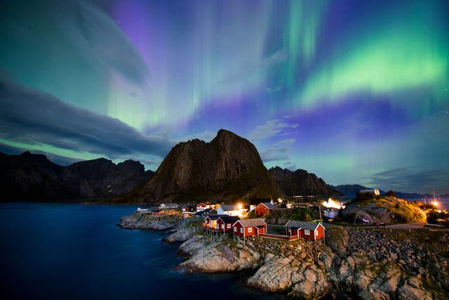 <p>Northern lights (aurora borealis) illuminate the sky over Reinfjorden in Reine, on Lofoten Islands, Arctic Circle, on September 8, 2017</p>