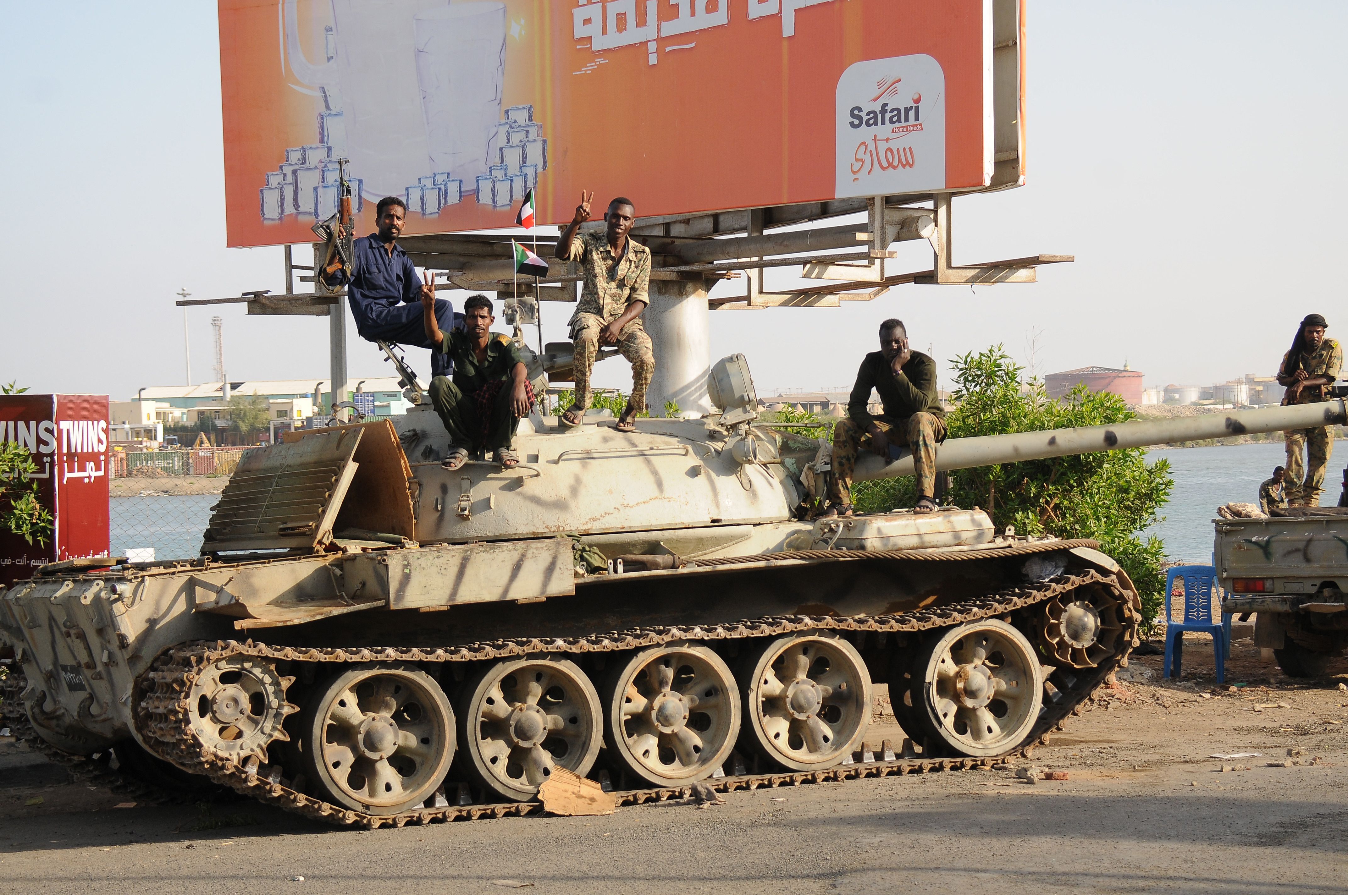 Sudanese army soldiers, loyal to army chief Abdel Fattah al-Burhan, sit atop a tank in the Red Sea city of Port Sudan, on 20 April 2023