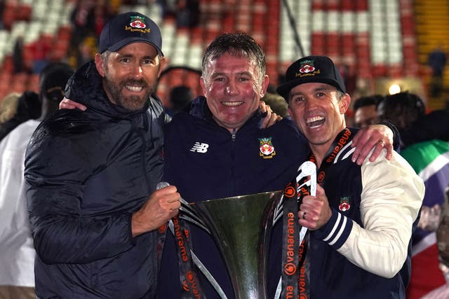 <p>Wrexham co-owners Ryan Reynolds and Rob McElhenney, and manager Phil Parkinson celebrated promotion from the National League last season </p>