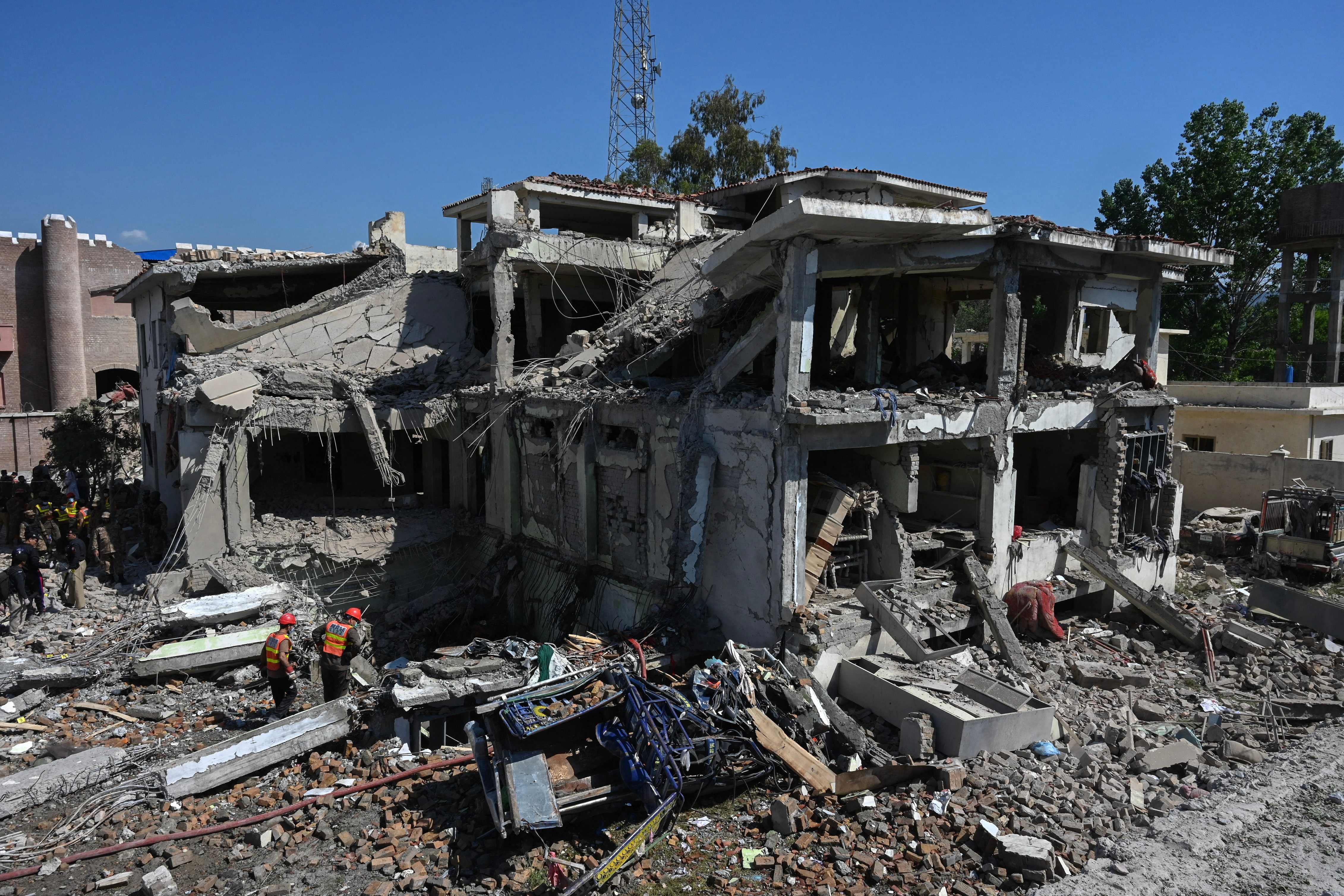 Rescue teams search for victims in the rubble of a badly damaged building a day after multiple explosions caused by fire in a munitions cache levelled a specialist counter-terrorism police station in Kabal