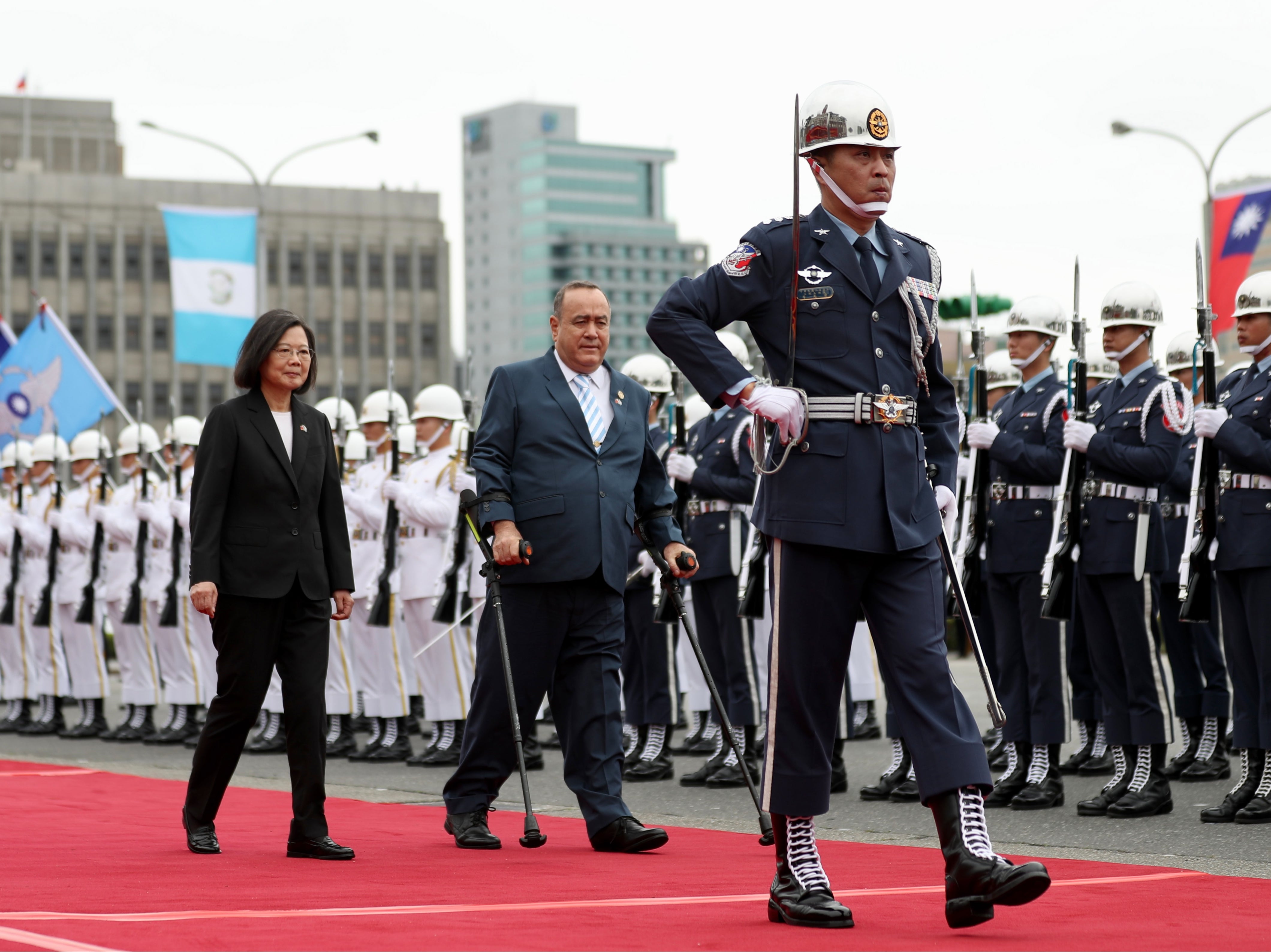 Taiwan president Tsai Ing-wen (L) and Guatemala president Alejandro Giammattei (C) review honor guards