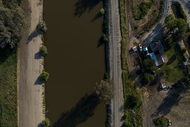 <p>A home sits next to the North Fork Kings River in the Island District of Lemoore, Calif., Wednesday, April 19, 2023. Residents in rural communities in the heart of the state are facing the prospect of being marooned by rising rivers or flooded out</p>