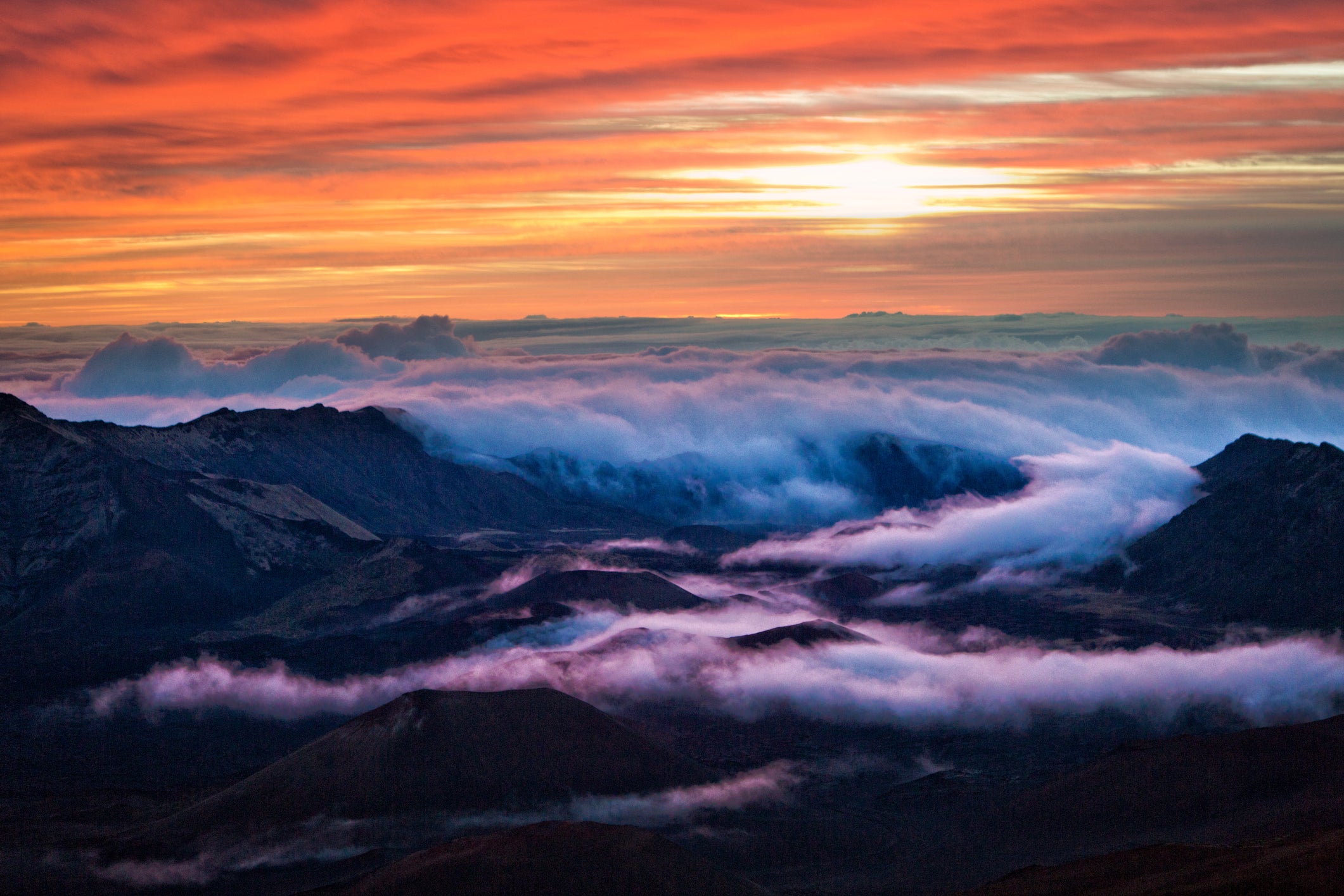Watch the sun rise above the clouds at the Haleakala Volcano, 10,000 feet above sea level