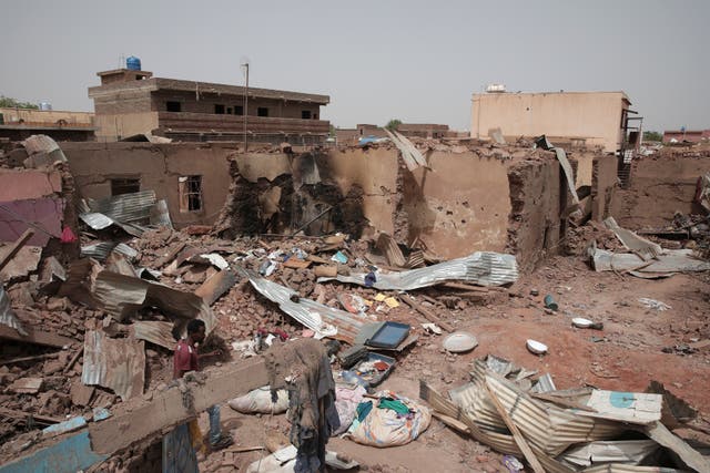 A man walks by a house hit in recent fighting in Khartoum, Sudan (Marwan Ali/AP)
