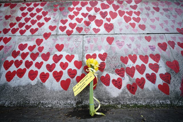 Flowers by the national Covid memorial wall in London (Yui Mok/PA)