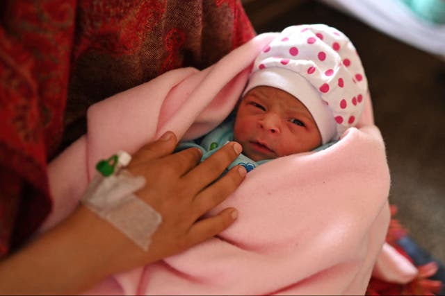 <p>Manu Bala holding her newborn daughter on Tuesday</p>