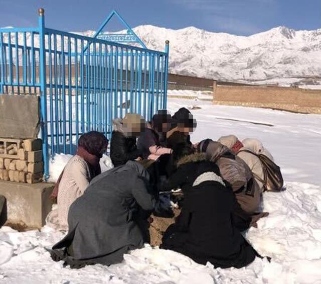 <p>The British children grieve for their father as they sit by his grave </p>