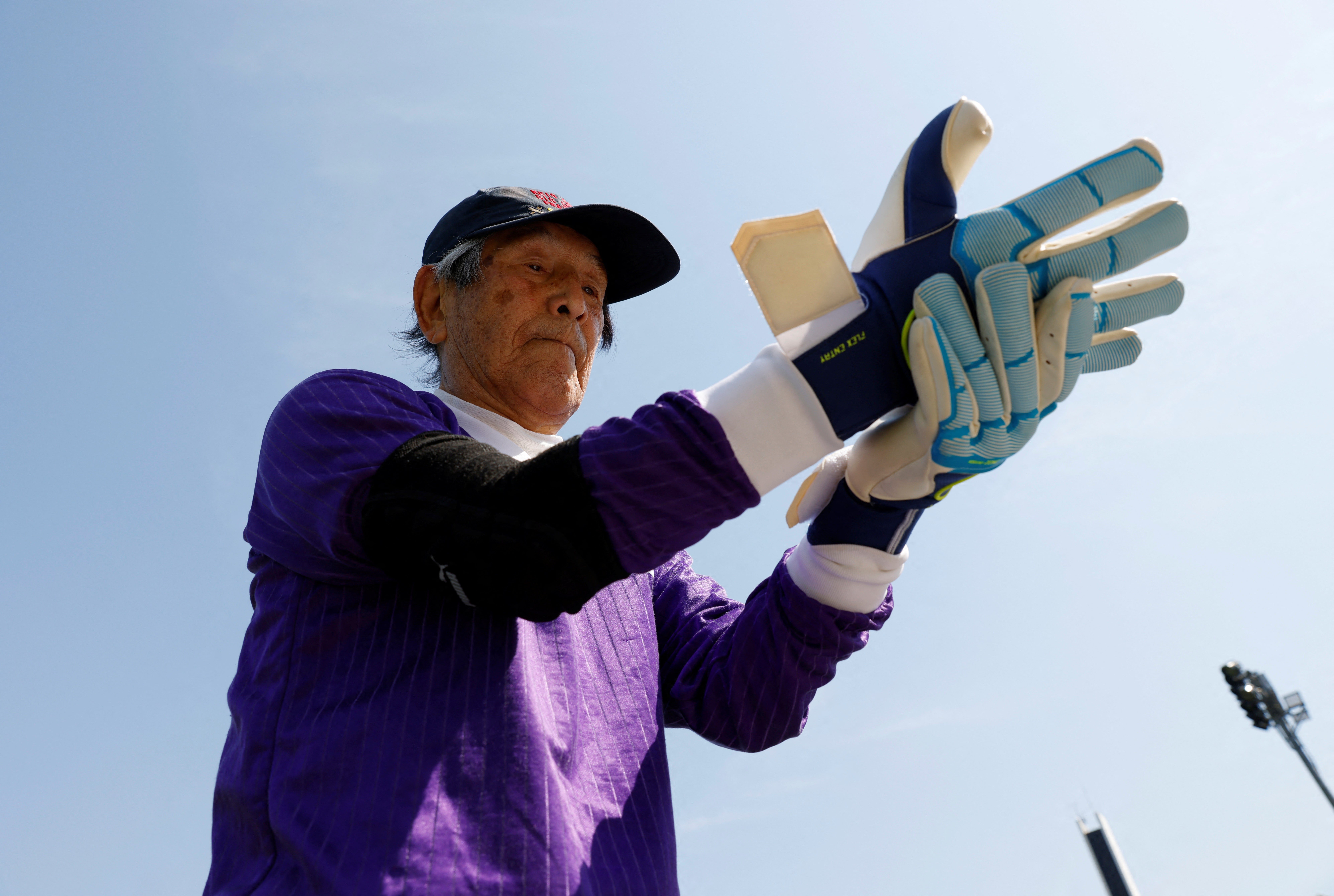 White Bear's Shingo Shiozawa, 93, puts on his goalkeeper gloves during a football practice